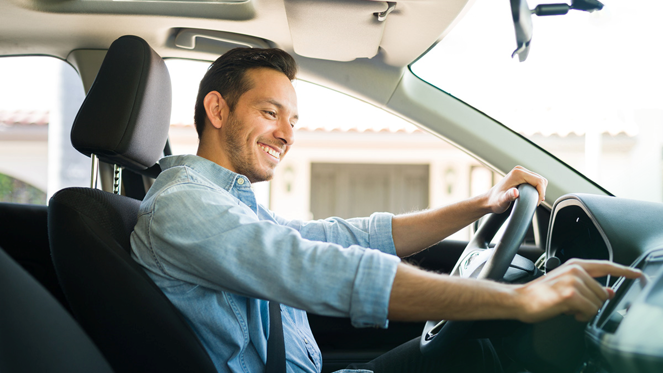 Lächelnder Mann im Auto drückt auf das Display